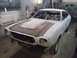 1978 Ford Mustang II - A 1978 Ford Mustang II is being worked on in a garage, showing its body in primer and a prominent hood scoop.