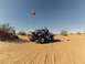 1970 Volkswagen Beetle - A blue Baja Bug, modified for off-road use, is parked in a sandy desert with a person standing beside it.