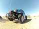 1970 Volkswagen Beetle - Customized blue Baja Bug with off-road tires and exposed engine in a desert landscape.