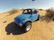 1970 Volkswagen Beetle - A blue 1970 Volkswagen Beetle Baja Bug is parked in a sandy desert landscape under a clear blue sky.