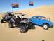 1970 Volkswagen Beetle - A blue Volkswagen Beetle Baja Bug is seen on sand dunes alongside two off-road vehicles.