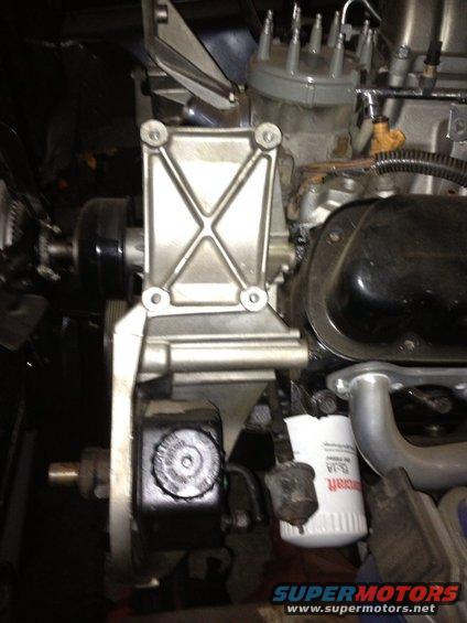 Close-up of engine component with oil filter and power steering reservoir