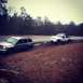 2001 Dodge 1500 - A white Dodge pickup truck is towing a silver SUV that appears to be stuck on the side of a wet, muddy road.