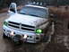 2001 Dodge 1500 - A white Dodge Ram pickup truck is stuck in a muddy ditch with its driver's side door open and a winch attached to the front.