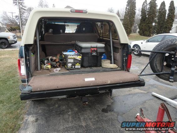 1995 Ford Bronco interior showing cargo area with tools, a toolbox, and a spare tire mounted externally