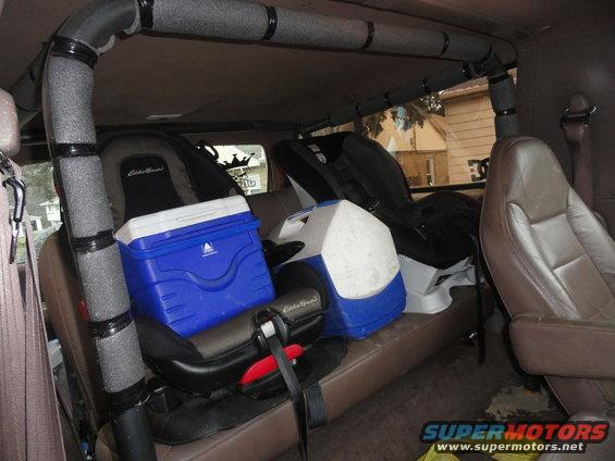 Interior view of a vehicle with two car seats and coolers on the back seat