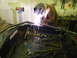 1990 Chevrolet Suburban - A person in protective gear welds a metal frame, with tools and a grinder visible in the background.