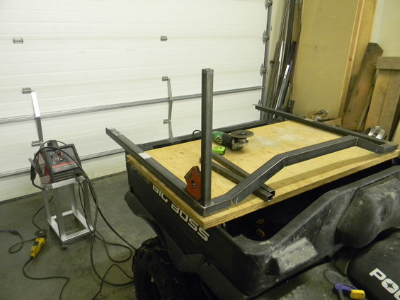 ATV with metal frame being built on top, welding equipment nearby