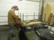 1990 Chevrolet Suburban - A person in welding gear works on a metal frame attached to the back of a green Polaris ATV.