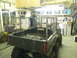 1990 Chevrolet Suburban - An ATV is parked in a garage, a metal cage around its bed and a man standing behind it.