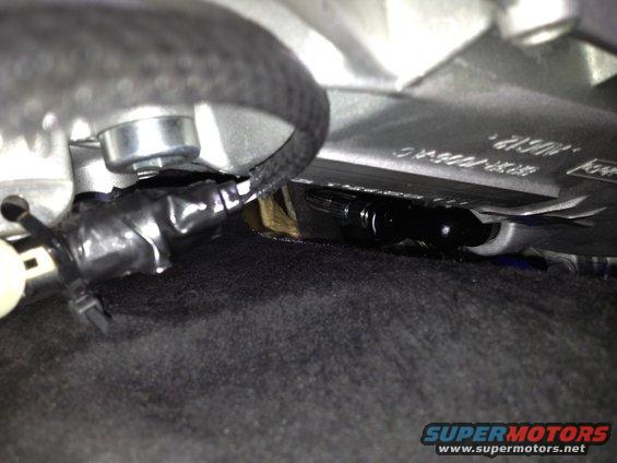 Close-up of black electrical tape wrapped around wires under a car seat