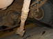 1992 Ford Bronco - Close-up view of the driveshaft and rear differential assembly of a vehicle, likely undergoing maintenance.