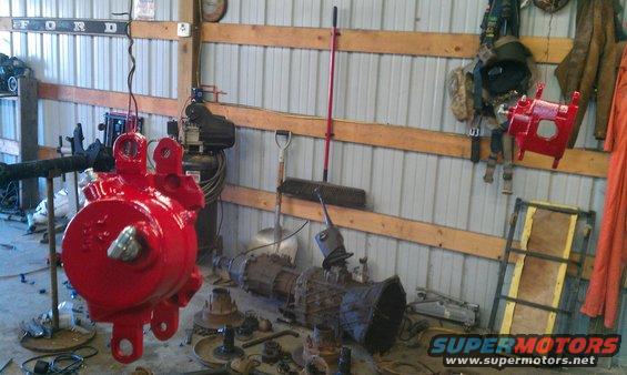 Red steering gear box hanging in a workshop with Ford sign