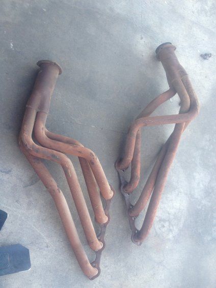 two rusty exhaust manifolds on a concrete surface