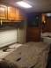 2003 Ford F-350 - Interior view of an RV bedroom, wooden cabinetry, a bed with two screwdrivers, and a television.
