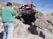 1993 Ford Bronco - A man photographs a 1993 Ford Bronco navigating a rocky off-road trail.