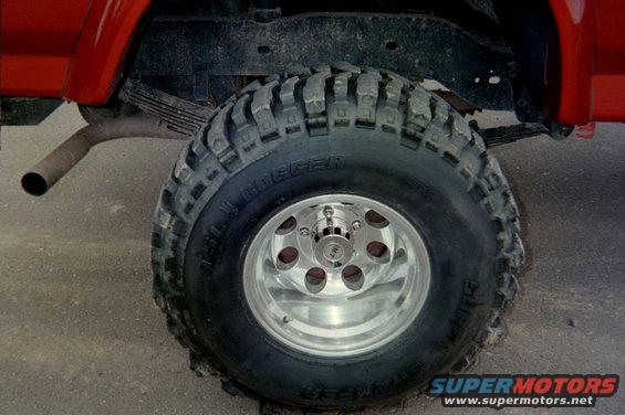 Red SUV rear tire with Super Swampers and chrome wheels