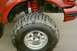 1995 Ford Bronco - Detail of a lifted vehicle's suspension and aggressive tread tire.