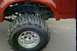 1995 Ford Bronco - A red SUV is shown from the side, focusing on its large off-road tire and fender.