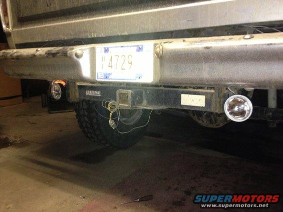 Rear bumper, trailer hitch, and license plate of a vehicle