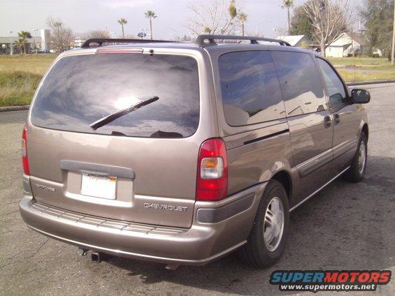 Tan 2005 Chevrolet Venture minivan, rear 3/4 view, with roof rack and trailer hitch