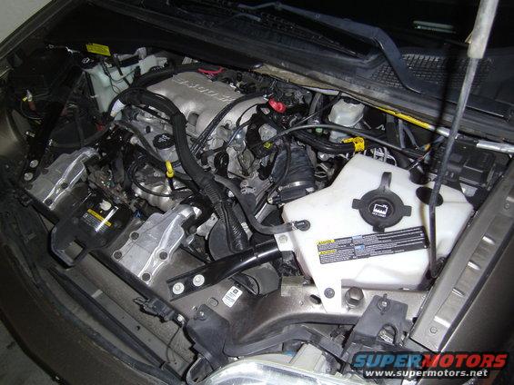 Engine bay of a 2005 Chevrolet Venture with the hood open, showing the engine, coolant reservoir, and various hoses