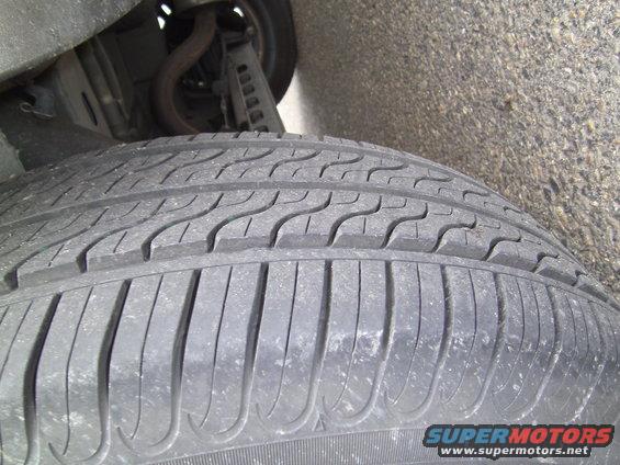 Close-up of a tire tread with suspension components visible above