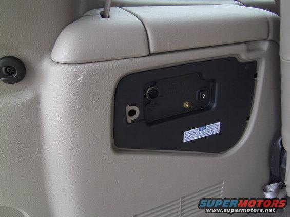 Interior power outlet and latch on a gray plastic panel