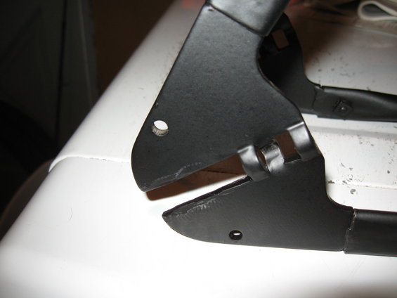 Black metal bracket with holes on a white surface