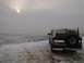 1992 Ford Bronco - A 1992 Ford Bronco is seen from the rear, parked on a snow-covered landscape under a hazy sun.