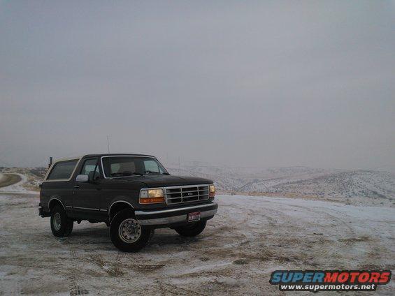 Dark 1992 Ford Bronco with white top in snowy landscape