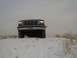 1992 Ford Bronco - A 1992 Ford Bronco sits on a snowy hill, its front grille clearly visible against the overcast sky.
