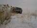 1992 Ford Bronco - Front view of a 1992 Ford F-Series truck partially obscured by dry grass in a snowy landscape.