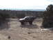 1986 Ford Bronco II - 1986 Ford Bronco II navigating a sandy off-road trail in a desert environment.