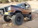 1986 Ford Bronco II - This modified 1986 Ford Bronco II navigates a sandy, off-road path with its large tires and lifted suspension.