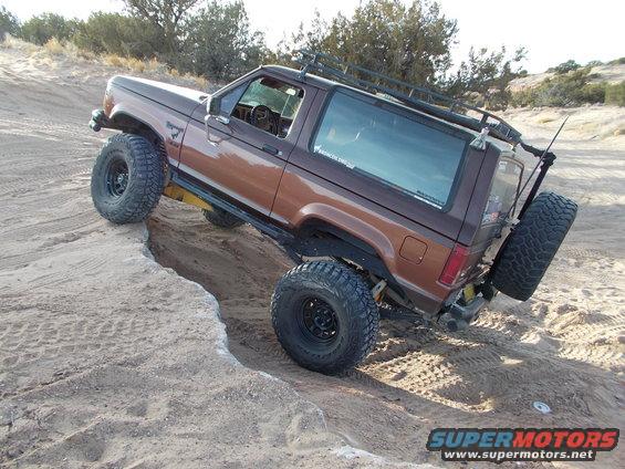 1986 Ford Bronco II with large tires climbing a dirt embankment