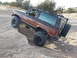 1986 Ford Bronco II - This 1986 Ford Bronco II is navigating a steep dirt incline, demonstrating its off-road capabilities.