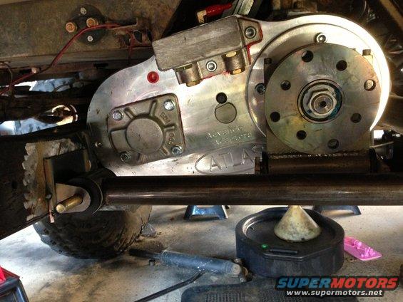 Atlas transfer case mounted on vehicle frame with visible bolts and hoses