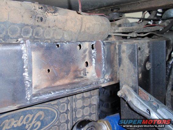 close-up of welded metal frame on vehicle, with Ford logo visible below