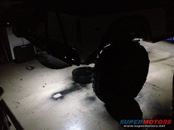 Undercarriage with rock lights installed, showing suspension and tires