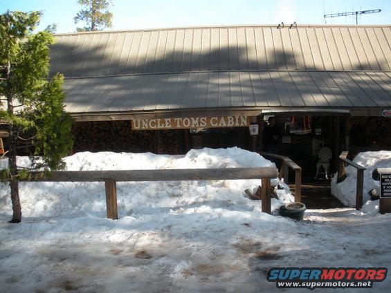 Uncle Tom's Cabin building entrance covered in snow, with a wooden sign above