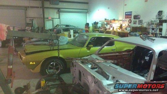 Lime green 1973 Chevrolet Camaro with black stripe, in garage