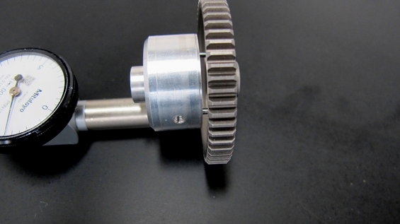 Dial indicator measuring a metal gear with teeth