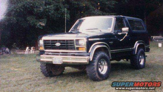 Black Ford Bronco with chrome wheels parked on grass