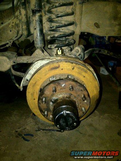 close-up of a rusty brake rotor and suspension components