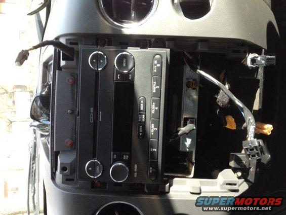 Car stereo and wiring removed from dashboard, showing exposed components