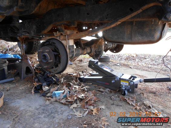 Rear axle and suspension of a vehicle on jack stands, undergoing maintenance