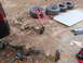 1986 Ford Bronco - Vehicle axles and tires are staged on concrete, along with a floor jack and tools.
