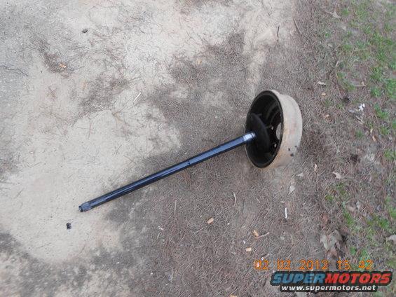 axle and brake drum assembly lying on the ground