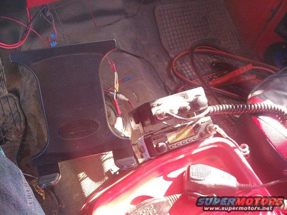 cb radios stacked on a red console with wires and jumper cables nearby